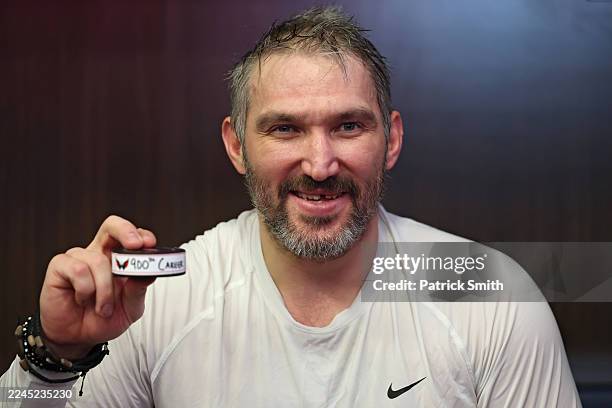 Alex Ovechkin of the Washington Capitals poses with the puck of his 900th career NHL goal that was scored against the St. Louis Blues at Capital One...