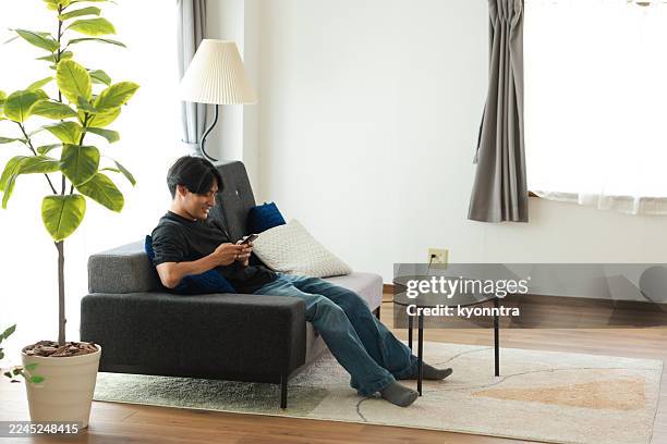 young man using a mobile - wide shot stock pictures, royalty-free photos & images