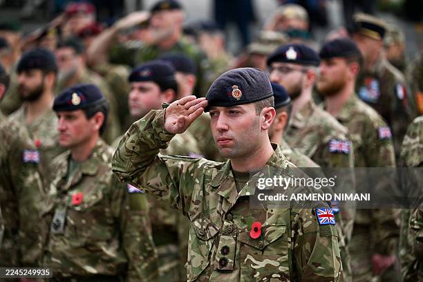 British soldiers serving in the Kosovo Force , a NATO-led international peacekeeping force in Kosovo, take part in a wreath laying ceremony as part...