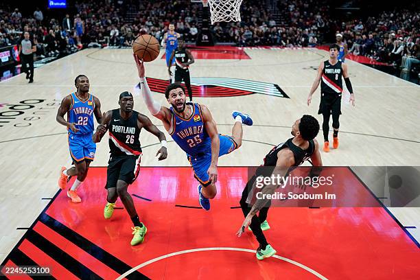 Toumani Camara of the Portland Trail Blazers draws a charge from Ajay Mitchell of the Oklahoma City Thunder during the first half at Moda Center on...