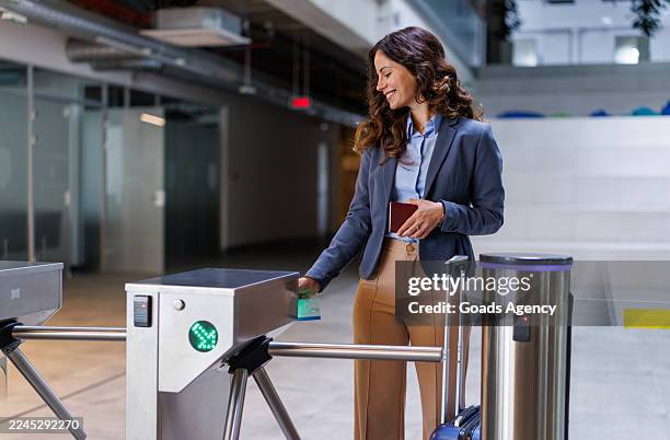businesswoman checking access control at airport turnstile - entrance gate stock pictures, royalty-free photos & images