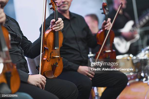 group of violinists in black attire playing string instruments during live session - orchestra rehearsal stock pictures, royalty-free photos & images