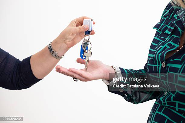 key exchange between two people, handing over keys in a modern setting - car key ring stock pictures, royalty-free photos & images