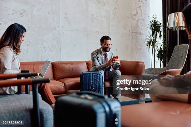 business travelers relaxing in airport lounge using technology - airport worker stock pictures, royalty-free photos & images