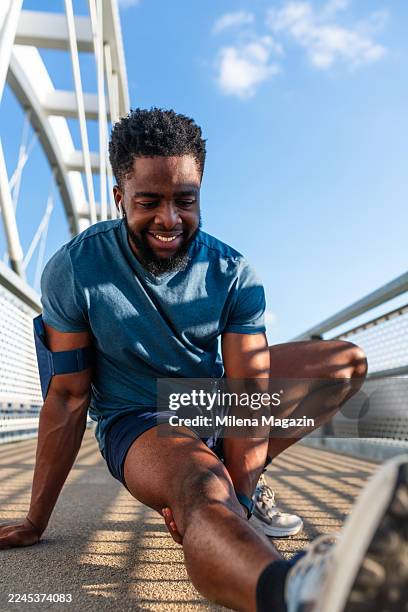 man stretching hamstring after running - hamstring stretch stock pictures, royalty-free photos & images