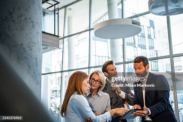 business colleagues collaborating on digital tablet in modern office - initiative stock pictures, royalty-free photos & images