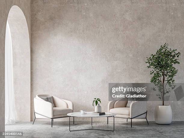 ein minimalistisches, schlichtes interieur mit einem paar weißer gemütlicher sessel und einem beistelltisch, einer topfpflanze vor einer verwitterten wand, auf betonboden, einer gewölbten tür oder einem fenster mit vorhängen - zementboden stock-fotos und bilder