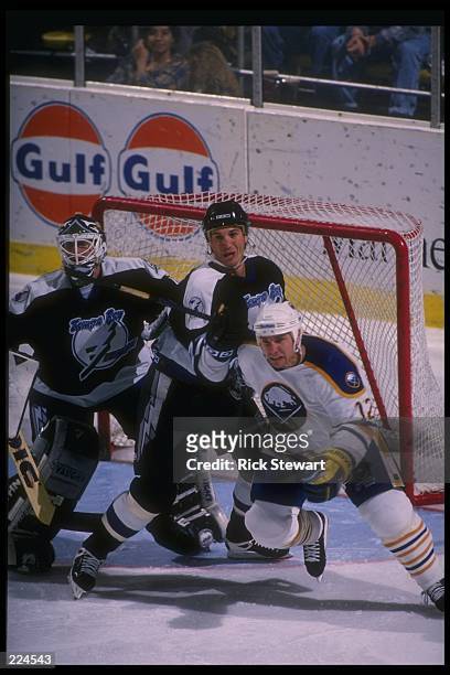 Tampa Bay Lightning goaltender Jeff Reese and defenseman David Shaw look on with Buffalo Sabres leftwinger Randy Burridge during a game at Memorial...