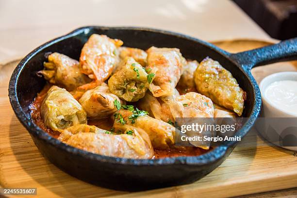 sarmale in cast iron pan with sour cream - kohlroulade stock-fotos und bilder