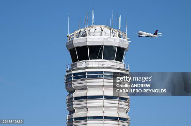 Sign displaying "Will Vector for Food" is displayed on the control tower as a Delta airline flight takes off from Ronald Reagan Washington National...
