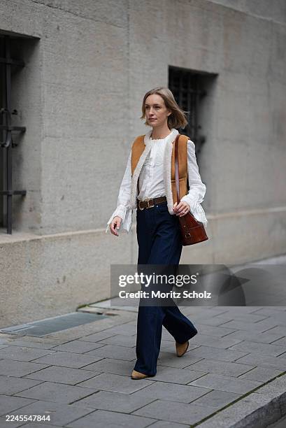 Marlies Pia Pfeifhofer is seen wearing a sleeveless camel brown suede vest with front patch pockets and shearling lining by Sézane; a white cotton...