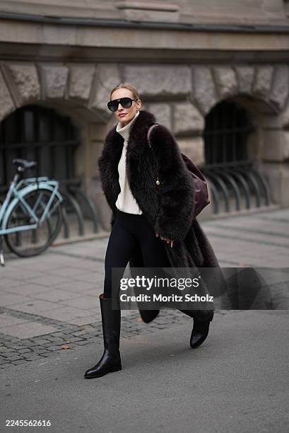 Marlies Pia Pfeifhofer is seen wearing a long dark brown faux fur coat with a voluminous collar and relaxed silhouette by Agolde; a cream cashmere...