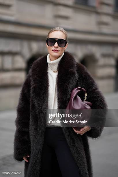 Marlies Pia Pfeifhofer is seen wearing a long dark brown faux fur coat with a voluminous collar and relaxed silhouette by Agolde; a cream cashmere...