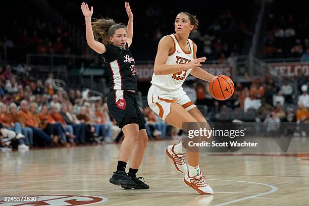 Aaliyah Crump of the Texas Longhorns looks to pass the ball while defended by Bianca Silva of the Louisiana Lafayette Ragin Cajuns during the first...