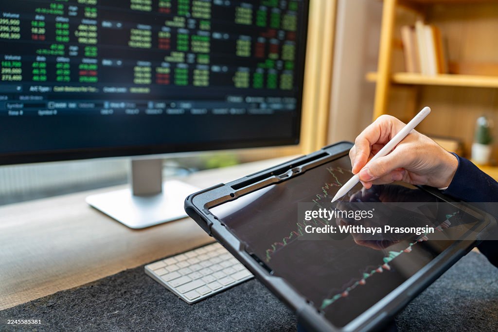 Person analyzing stock market data on tablet