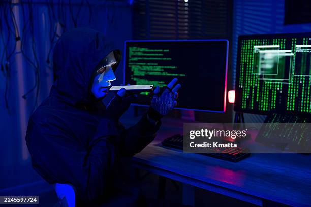 unidentified hacker exploiting a smartphone vulnerability for cybercrime, emphasizing mobile security risks, identity theft, and financial fraud. - phishing attack stock pictures, royalty-free photos & images
