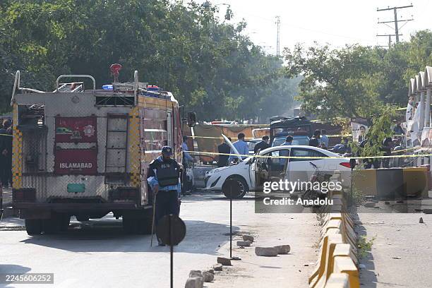 Security forces take measures at the scene where at least 12 people were killed and several others injured in an explosion outside a court complex in...