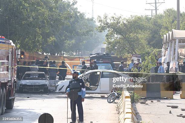 Security forces take measures at the scene where at least 12 people were killed and several others injured in an explosion outside a court complex in...