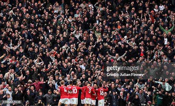 Bryan Mbeumo of Manchester United celebrates scoring his team's first goal with teammates in front of the away fans during the Premier League match...