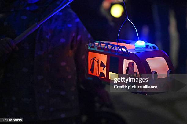 November 2025, Saxony-Anhalt, Halle: On St. Martin's Day, people with lanterns walk through Halle's city center. Accompanied by trumpets, the...