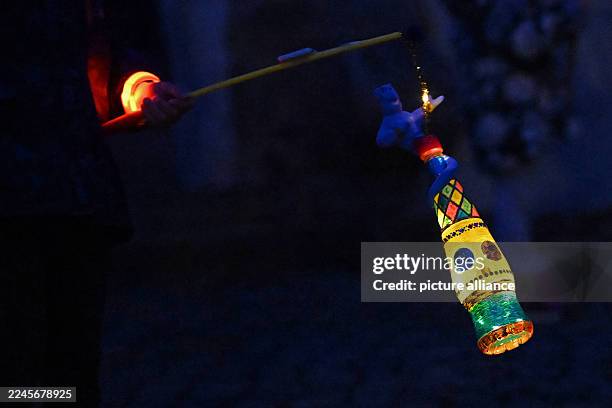 November 2025, Saxony-Anhalt, Halle: On St. Martin's Day, people with lanterns walk through Halle's city center. Accompanied by trumpets, the...