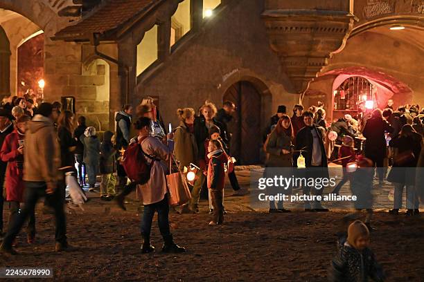 November 2025, Saxony-Anhalt, Halle: People arrive in the courtyard of Moritzburg Castle after the lantern procession. In the Catholic Church,...