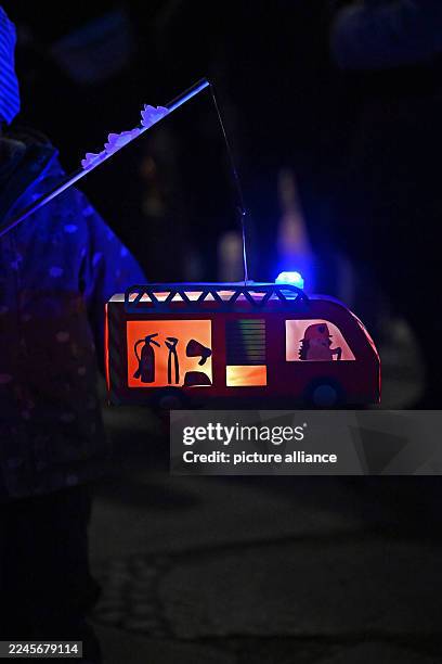 November 2025, Saxony-Anhalt, Halle: On St. Martin's Day, people with lanterns walk through Halle's city center. Accompanied by trumpets, the...