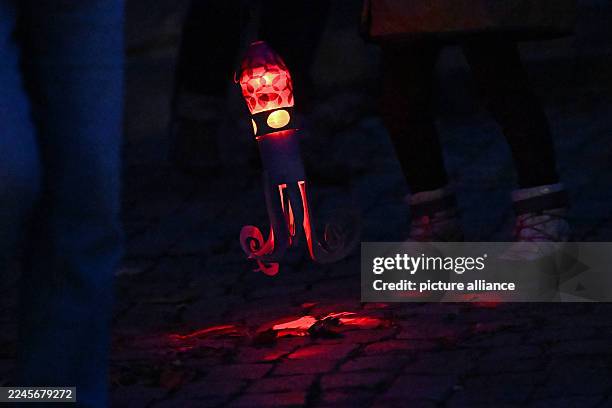 November 2025, Saxony-Anhalt, Halle: On St. Martin's Day, people with lanterns walk through Halle's city center. Accompanied by trumpets, the...