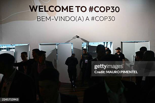 Security personnel block entrance doors as Indigenous people and students attempt to storm the venue during the COP30 UN Climate Change Conference in...