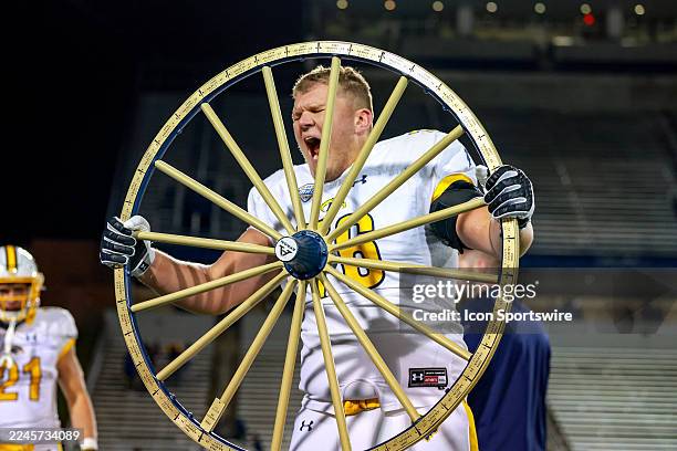 Kent State Golden Flashes offensive lineman Garrett Masterson celebrates with the Wagon Wheel following the college football game between the Kent...