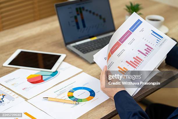 business person analyzing financial data and charts - marktonderzoek stockfoto's en -beelden