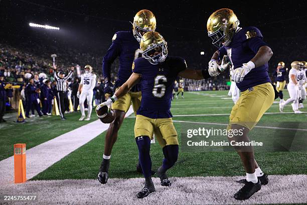 Jordan Faison of the Notre Dame Fighting Irish celebrates a touchdown with teammates Malachi Fields and Ty Washington during the second quarter...