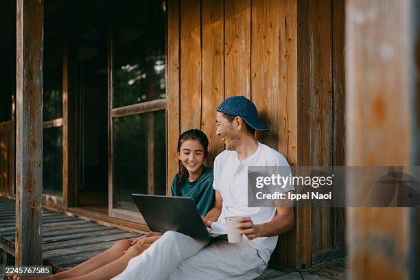 father and daughter using laptop on engawa (veranda) of japanese house - modern manhood stock pictures, royalty-free photos & images