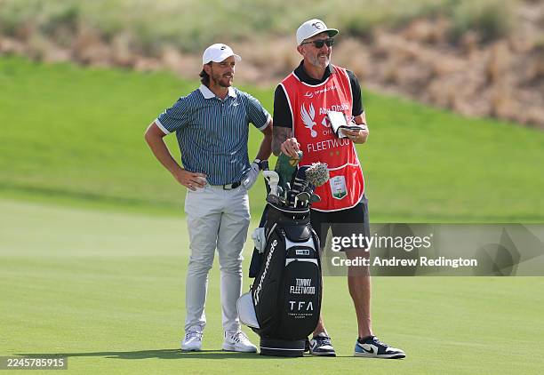 Tommy Fleetwood of England interacts with his caddie, Ian Finnis, on the second hole on day four of the Abu Dhabi HSBC Championship 2025 at Yas Links...