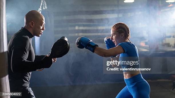 athlete preparing for boxing match with coach in training gym - boxer training stock pictures, royalty-free photos & images