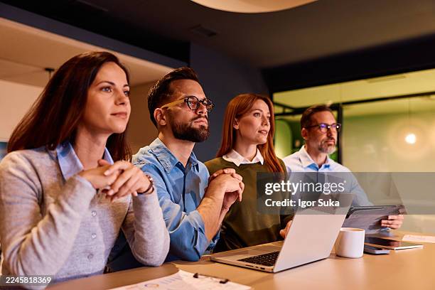 business people concentrating listening during office meeting - four people stock pictures, royalty-free photos & images