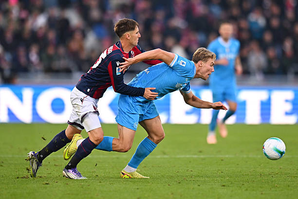 Rasmus Hojlund of Napoli runs with the ball whilst under pressure from Juan Miranda of Bologna FC 1909 during the Serie A match between Bologna FC...