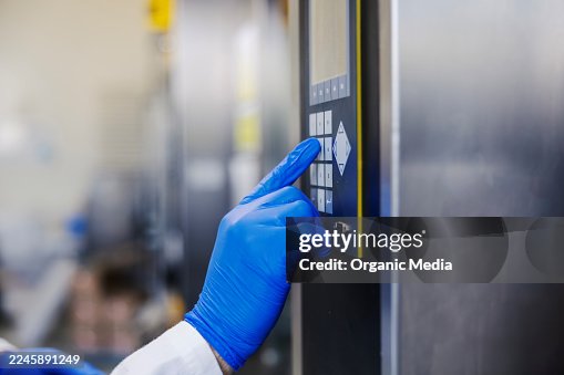 Hand in blue glove pressing control panel button Hand in blue glove pressing control panel button