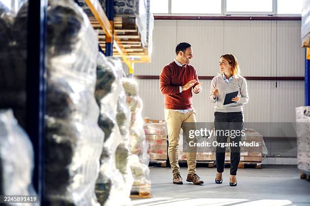 colegas caminando por el almacén discutiendo logística e inventario - proveedores fotografías e imágenes de stock