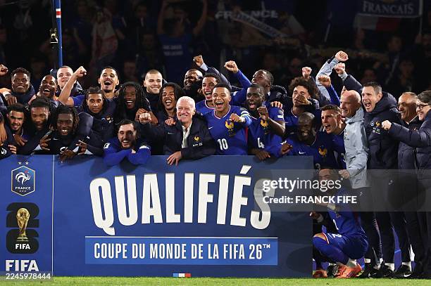 France's head coach Didier Deschamps flanked by France's forward Kylian Mbappe celebrate with teammates and members of staff after winning the 2026...