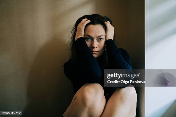 woman sitting on floor with hands in hair feeling anxious, stressed, and overwhelmed - terrified stock pictures, royalty-free photos & images