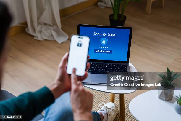 person using smartphone for two-factor authentication on laptop - personal data stock pictures, royalty-free photos & images
