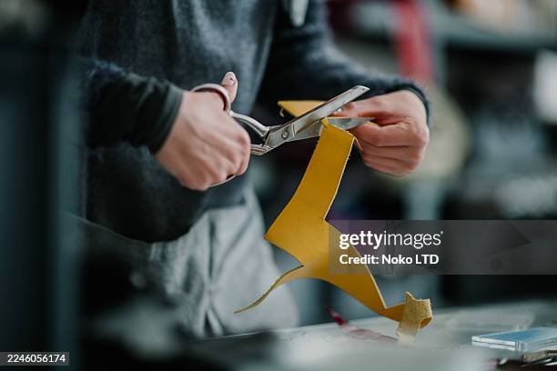 craftsperson cutting yellow leather using scissors - craft product stock pictures, royalty-free photos & images