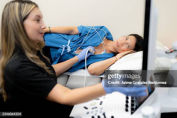 medizinisches fachpersonal, das ein echokardiogramm an einer patientin durchführt - echokardiogramm stock-fotos und bilder