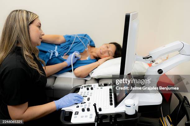 sonograph, der echokardiogramm-ultraschall an einer patientin durchführt - echokardiogramm stock-fotos und bilder