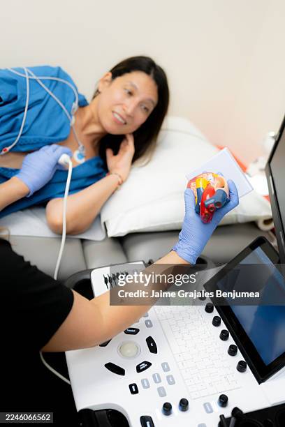 arzt, der ein echokardiogramm am patienten durchführt und die herzgesundheit erklärt - echokardiogramm stock-fotos und bilder