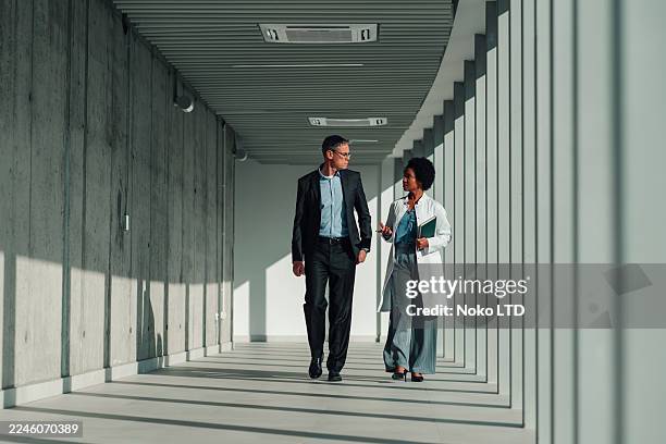 doctor and businessman walking discussing medical technology - medical director stock pictures, royalty-free photos & images