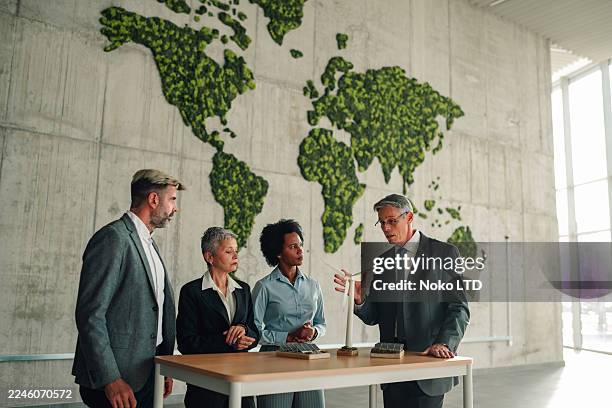 business team discussing renewable energy solutions and sustainability strategy - carbon neutrality stock pictures, royalty-free photos & images