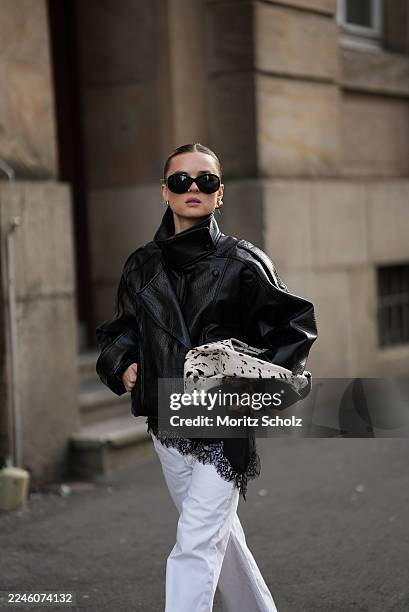Duesseldorf, GERMANY Romina Meier is seen wearing an oversized black viral leather PU jacket with a funnel neck collar, wide oversized silhouette and...