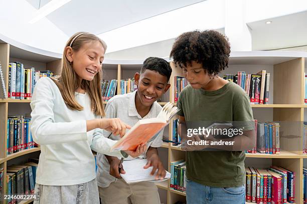 students reading a book at the school library and laughing - bibliotek bildbanksfoton och bilder